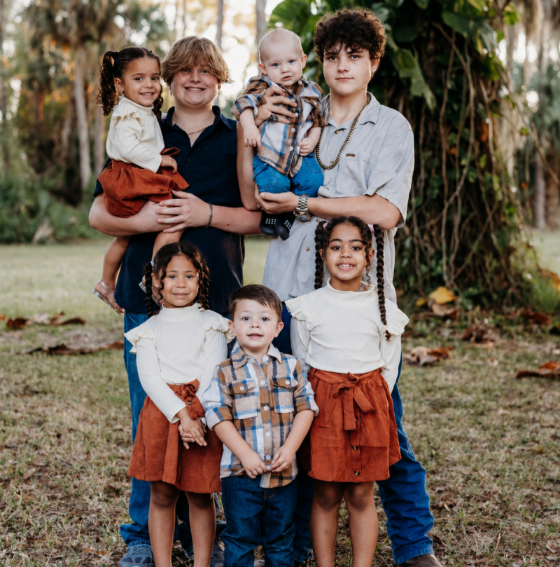Group of children posing outdoors together.